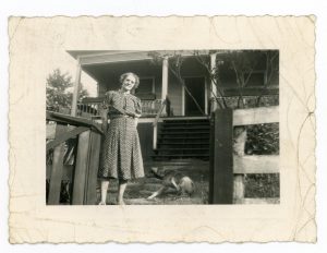 Lula May Thomas Craft by the front steps of her house.
