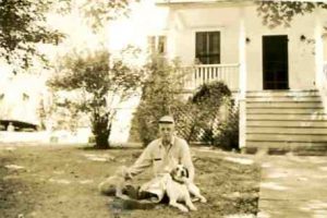 Paul Reese Maxey about 1950 with his dogs in front of the house 